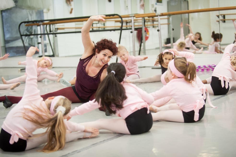 Giselle zit tussen de kinderen tijdens de balletles